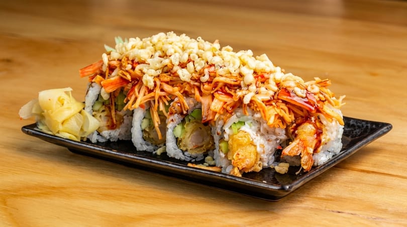 Sushi rolls with tempura shrimp, crab, and crispy toppings, served with pickled ginger.