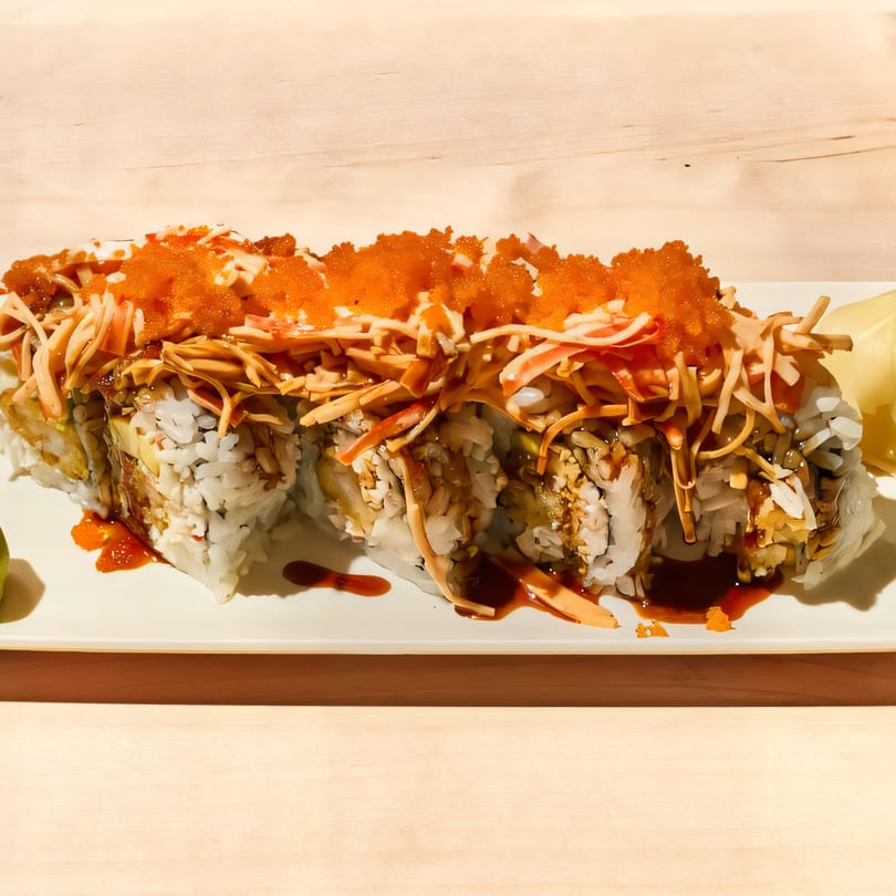 Sushi Go's sushi roll with orange roe, shredded crab, and dark sauce on a white plate.