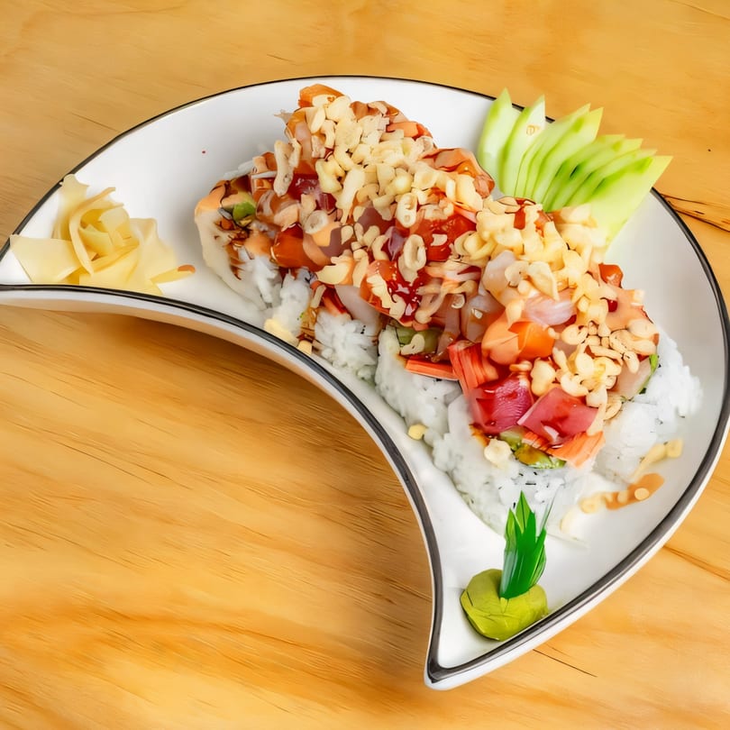 Sushi Go's colorful sushi rolls topped with sauces, nuts, and fresh ingredients, served with ginger and wasabi.